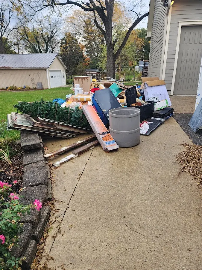 Dumpster being loaded with debris for Estate Cleanout Dumpster Rental in Holly Springs